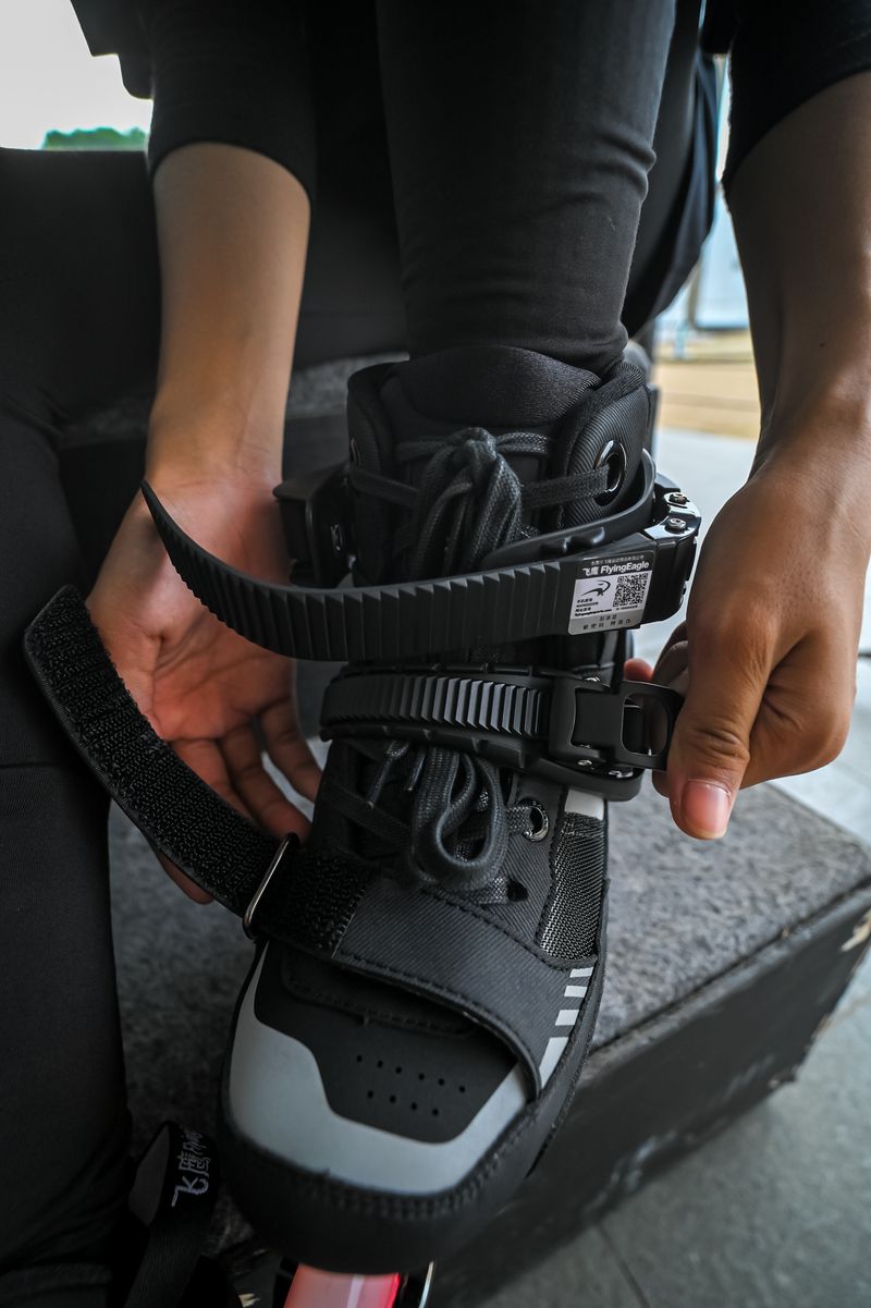 Hands fastening the buckle of a black inline skate