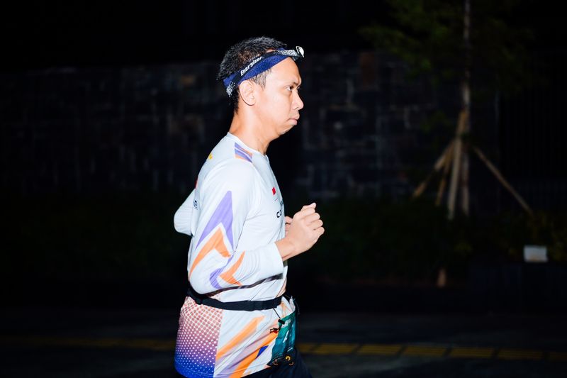 Side profile of a runner wearing a headlamp at night