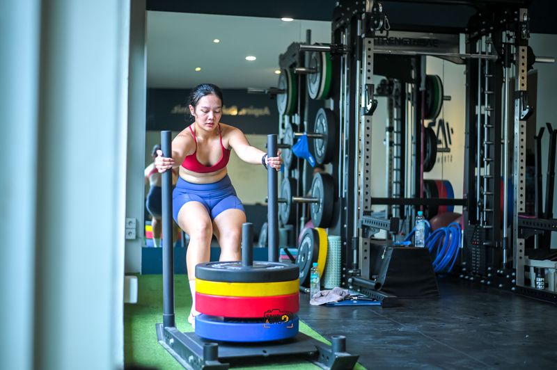 Athlete pushing a loaded sled across the gym floor