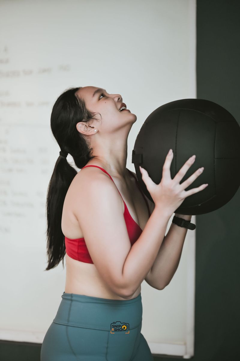 Athlete holding a medicine ball and looking upward during a gym session
