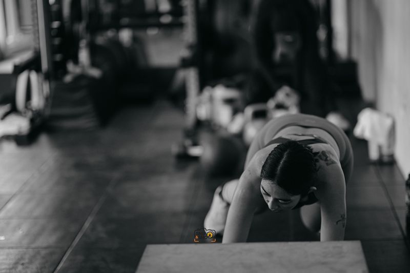 Black-and-white photograph of athletes working close to the gym floor