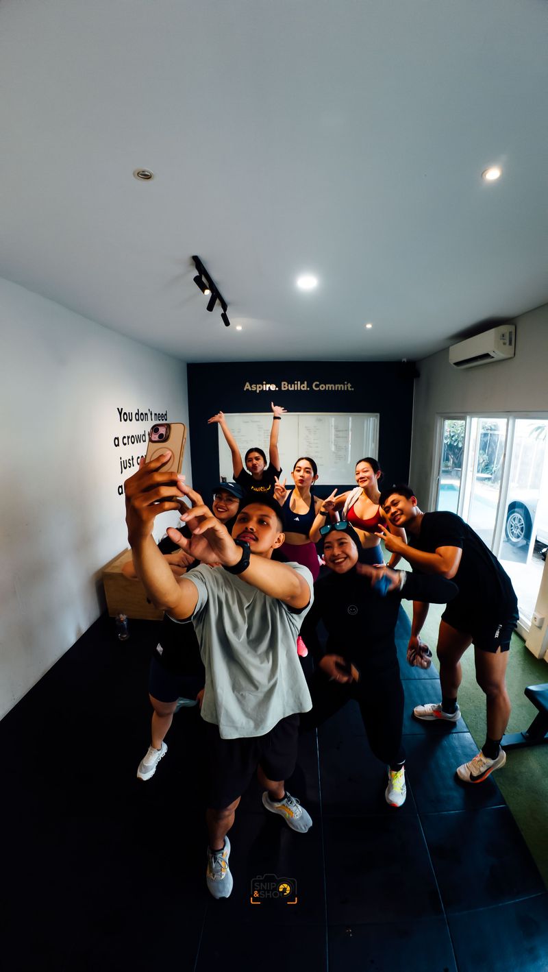 Group of athletes smiling and gathering for a selfie after training